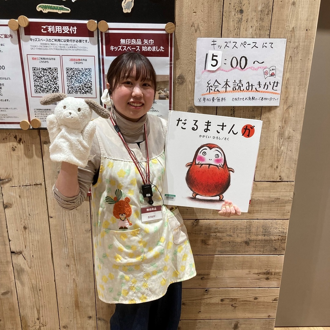 キッズスペースにてスタッフが絵本の読み聞かせをしている様子