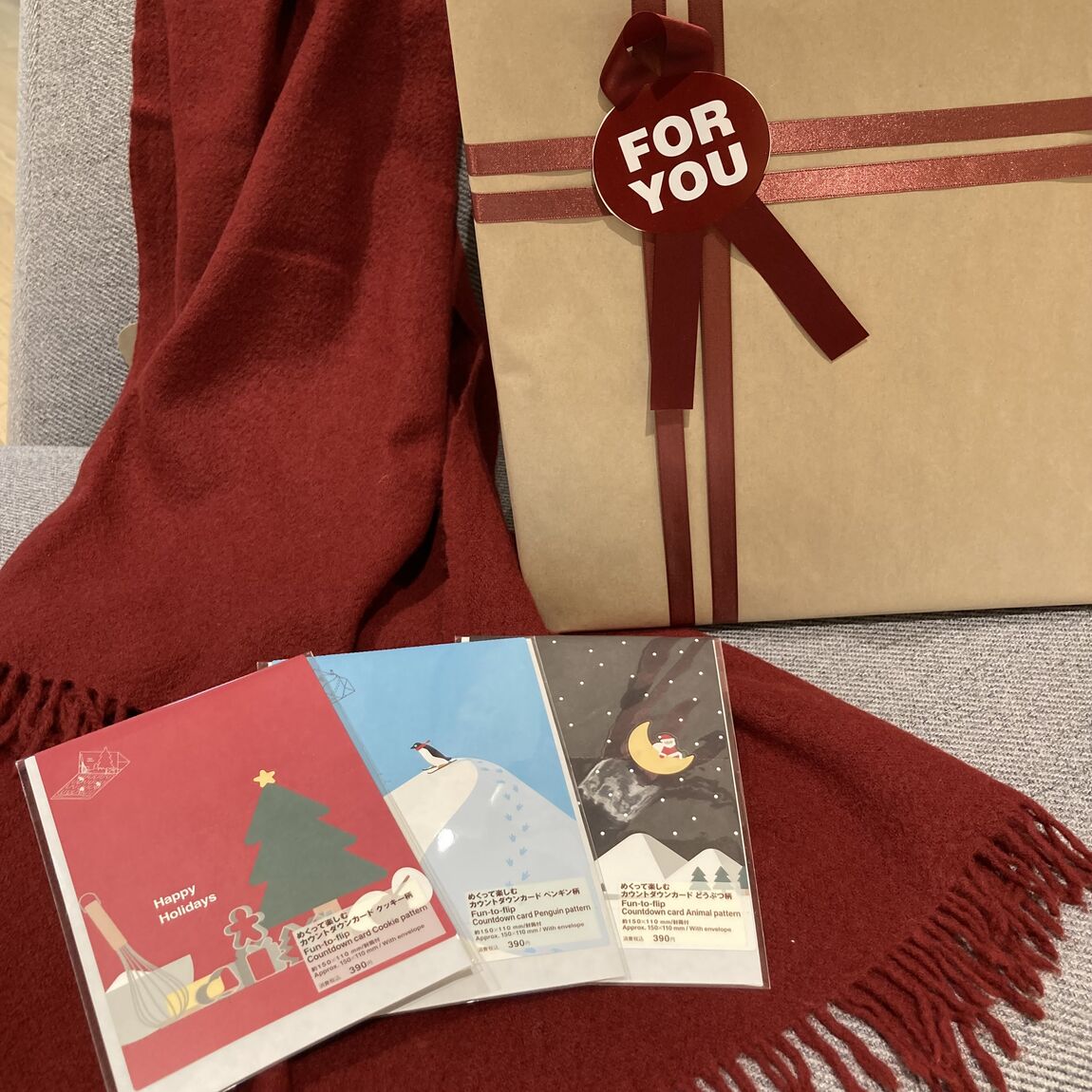 ソファに赤いストールの上にポストカードを３つ並べている