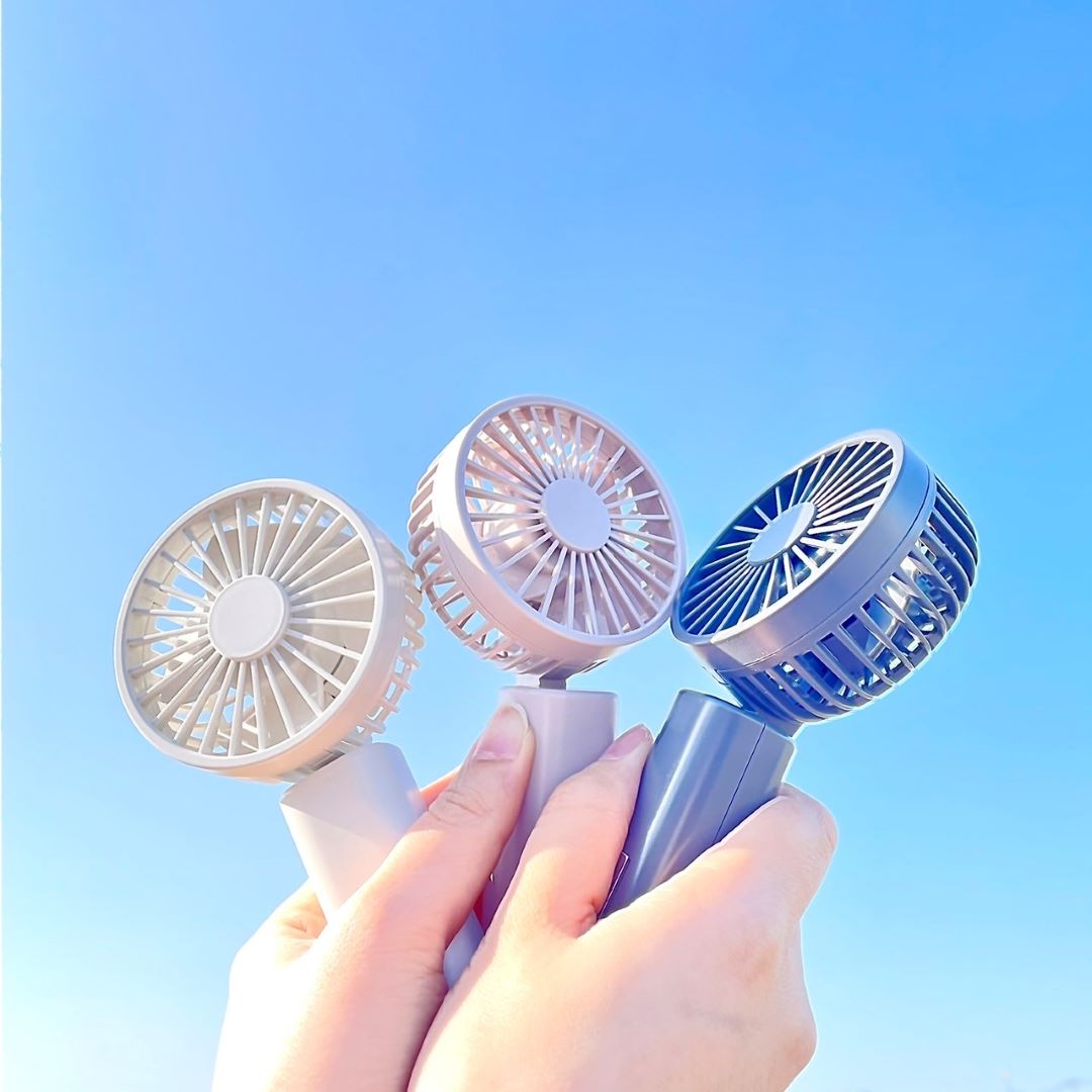 ハンディファンを青空に掲げている写真