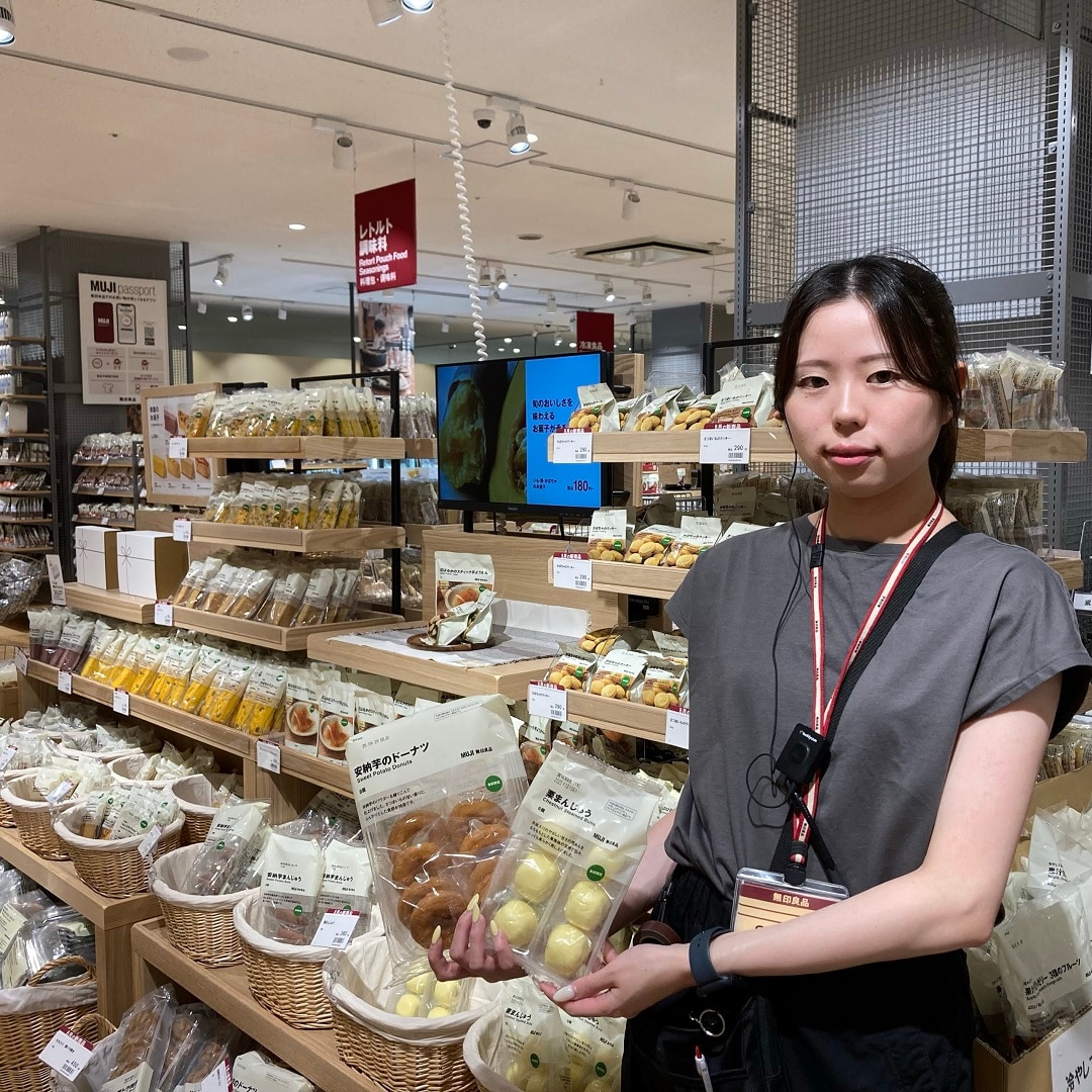 季節のお菓子を持ってほほえむスタッフの写真