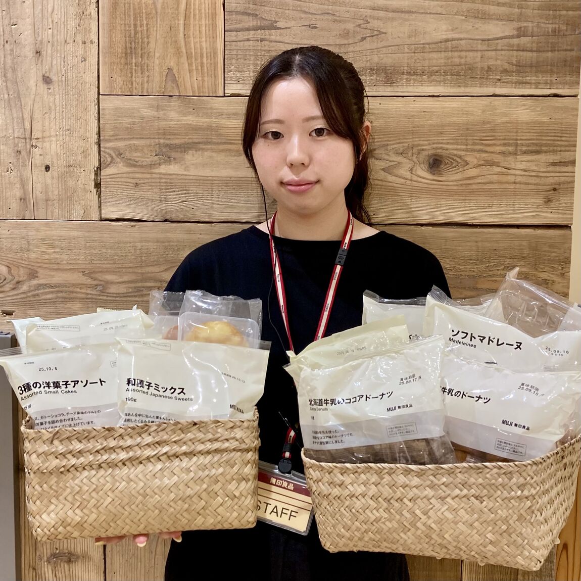 大袋のお菓子各種が入ったバスケットを両手に持つスタッフの写真