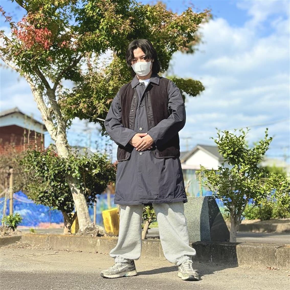 ステンカラーコートの上にフリースベストを合わせたコーディネートのスタッフの写真です。