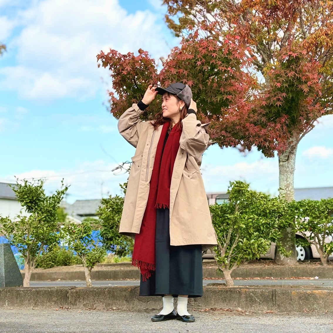 フライトキャップと赤いマフラーでカジュアルにコーディネートしたスタッフの写真です。