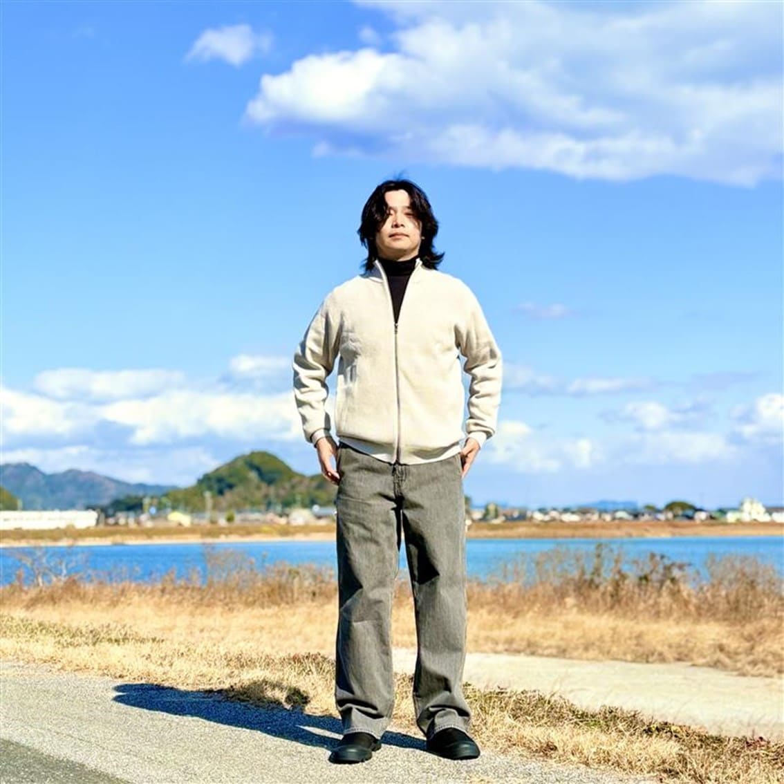 フルジップニットカーディガンに起毛のハイネックTシャツを合わせたコーディネートのスタッフです。