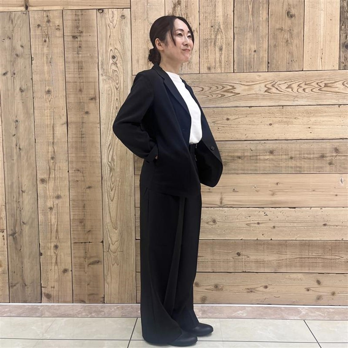 撥水ストレッチのテーラードジャケットにタックストレートパンツを合わせたコーディネートのスタッフの写真です。