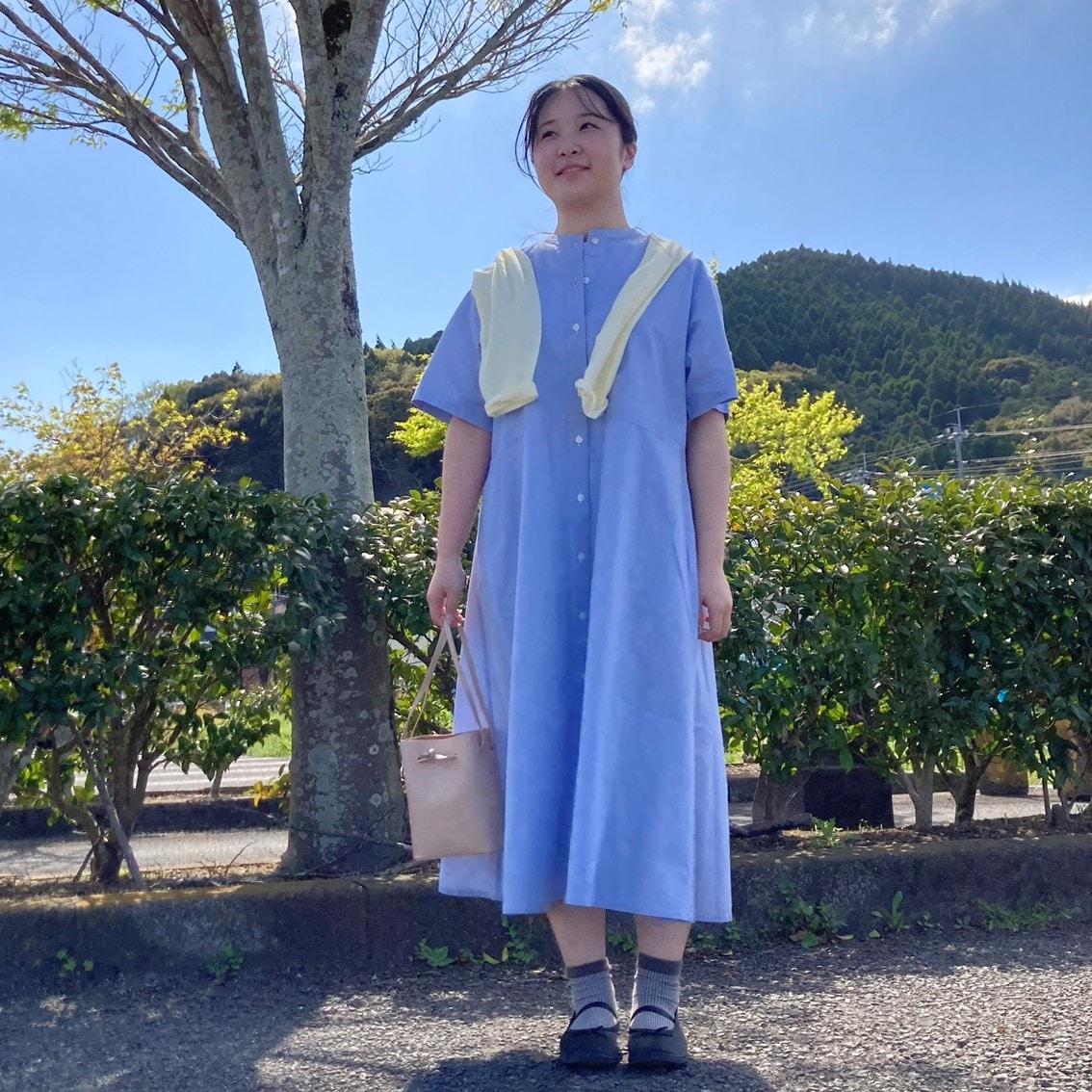 涼感半袖シャツワンピースに強撚天竺編み長袖Tシャツを肩にかけるコーディネートにしたスタッフの写真です。