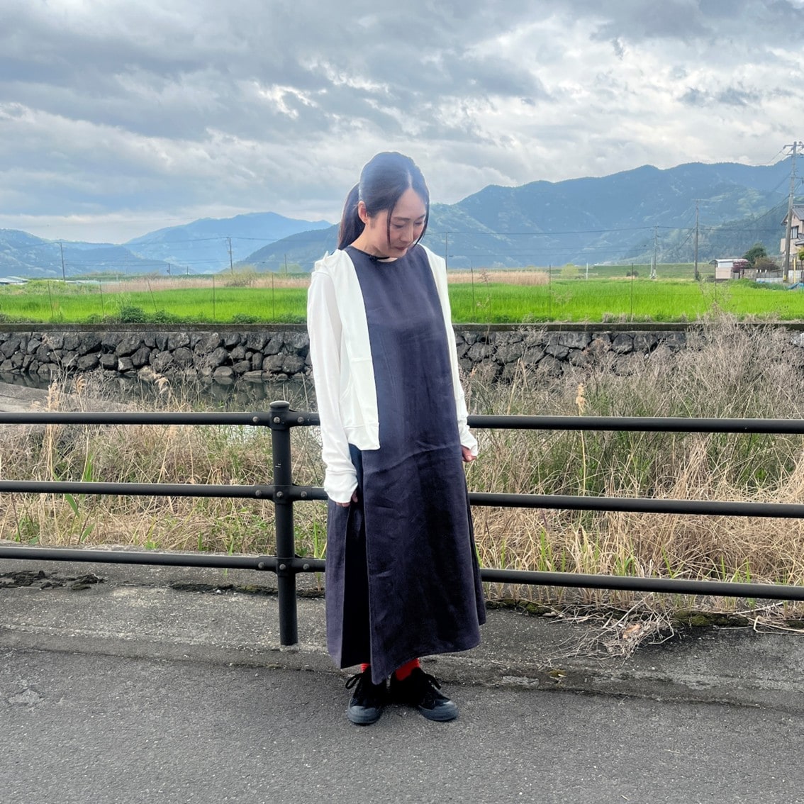 リネンのスリーブレスワンピースにフルジップパーカを合わせたコーディネートのスタッフの写真です。