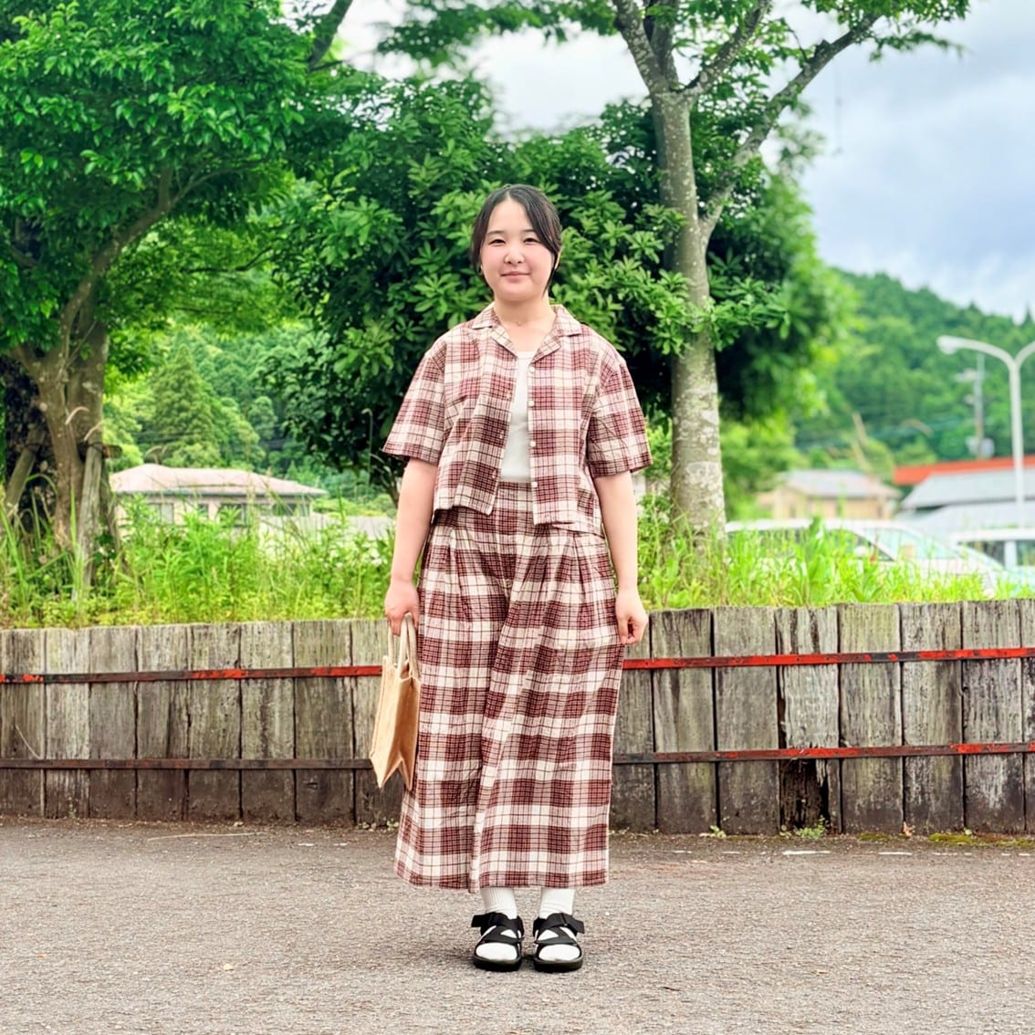 マドラスチェックの半袖ブラウスとスカートパンツのセットアップにしたスタッフの写真です。