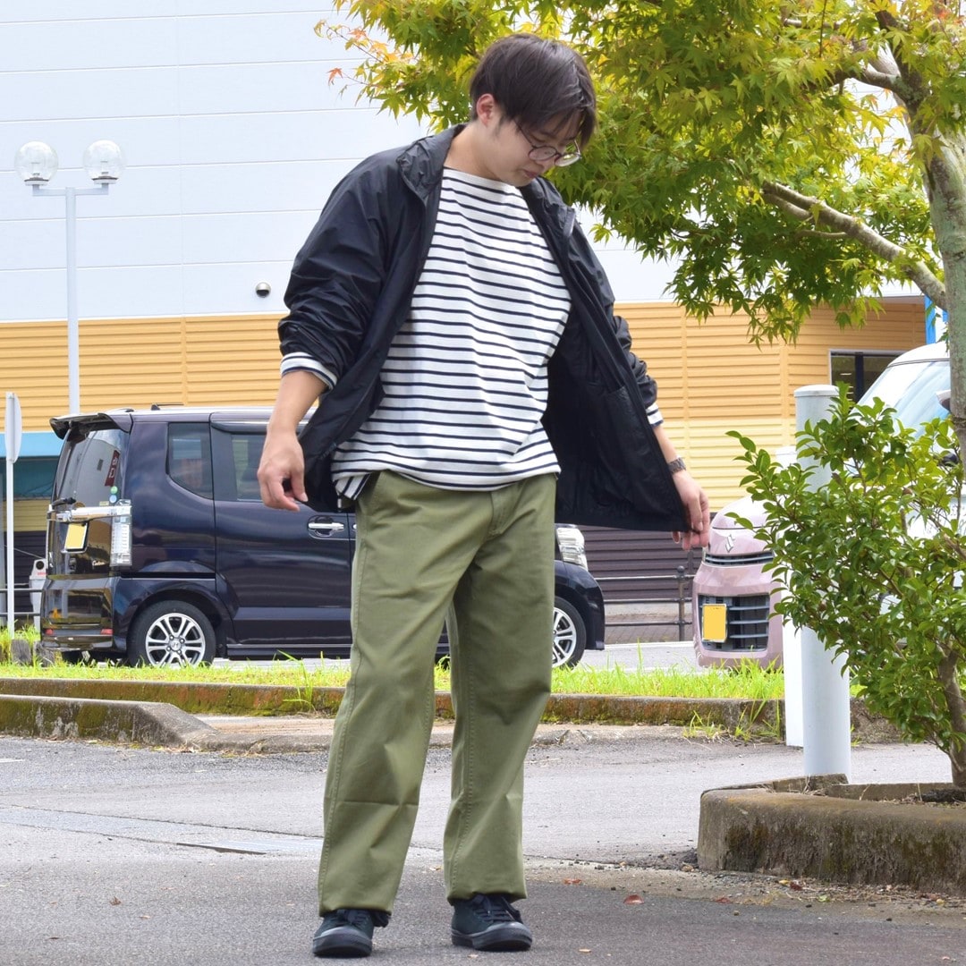 ポケッタブルウィンドブレーカーとボートネック九分袖Tシャツを合わせたコーディネートのスタッフです。