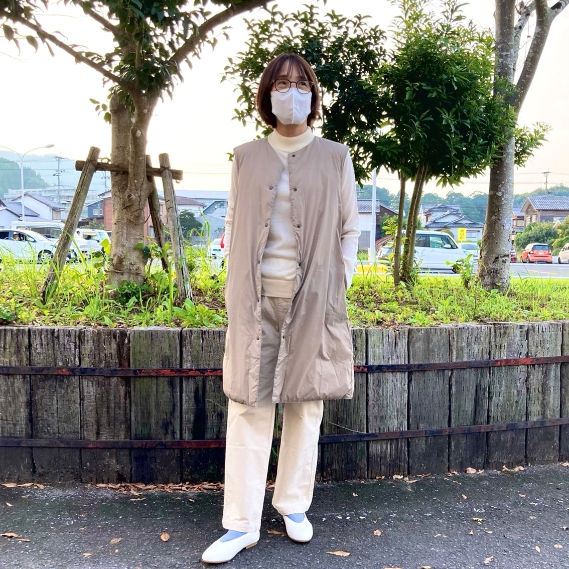 ハイネックセーターにノーカラーロングベストを合わせたコーディネートのスタッフ写真です。