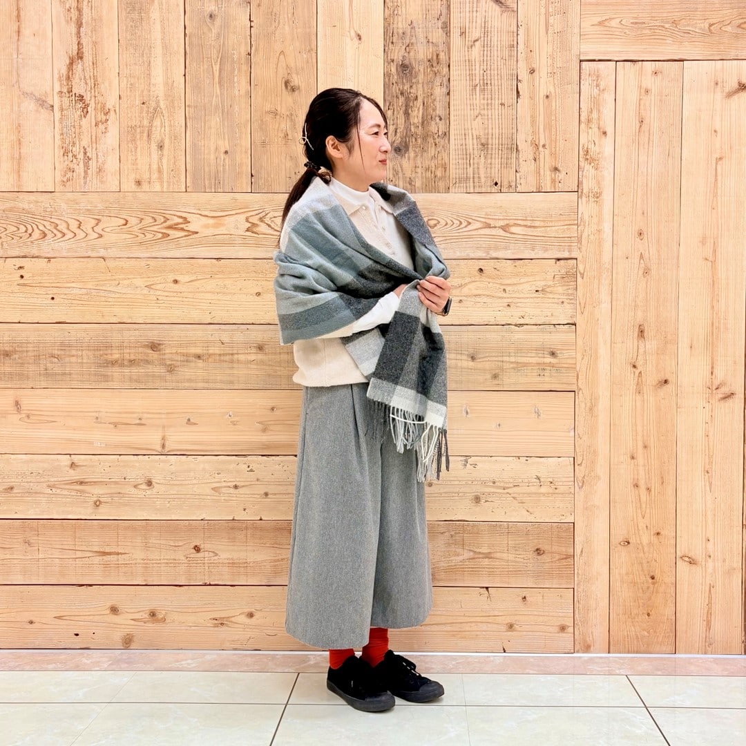 ブークレニットポロにストールを合わせたコーディネートしたスタッフの写真です。