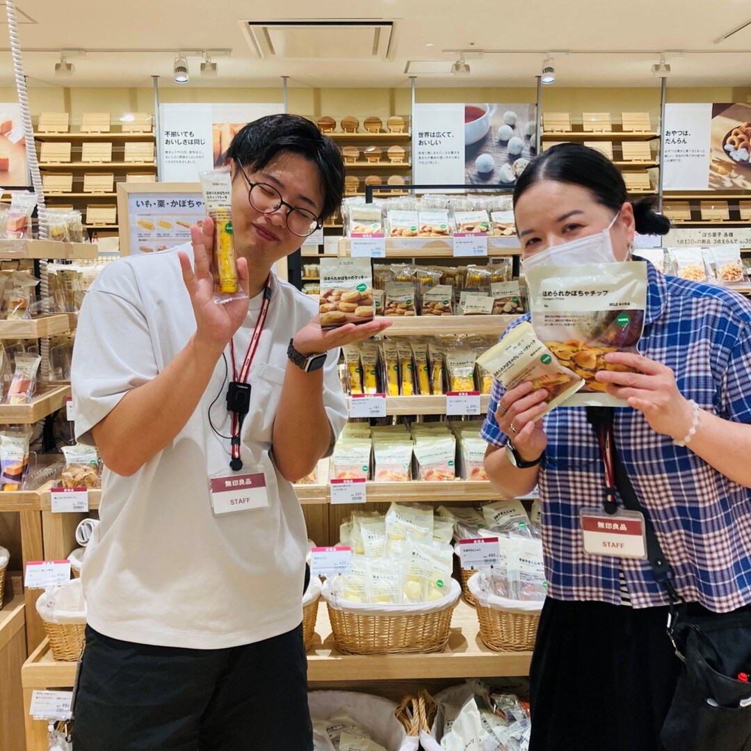 お菓子を持ったスタッフの写真です。