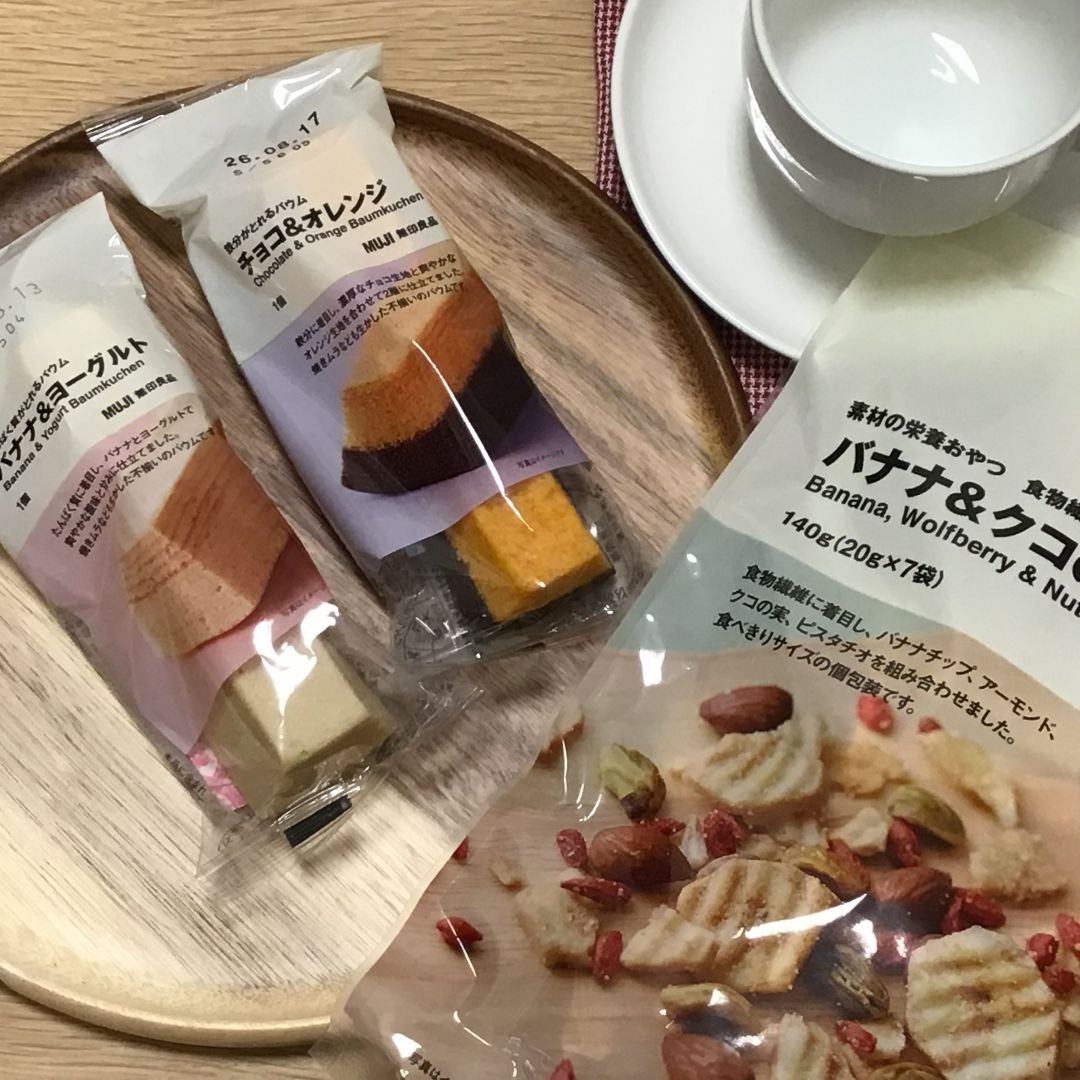 朝食風の画像。定番商品「素材の栄養おやつ　食物繊維　バナナ＆クコの実」と新商品「たんぱく質がとれるバウム　バナナ＆ヨーグルト」、「鉄分がとれるバウム　チョコ＆オレンジ」が並んでいる