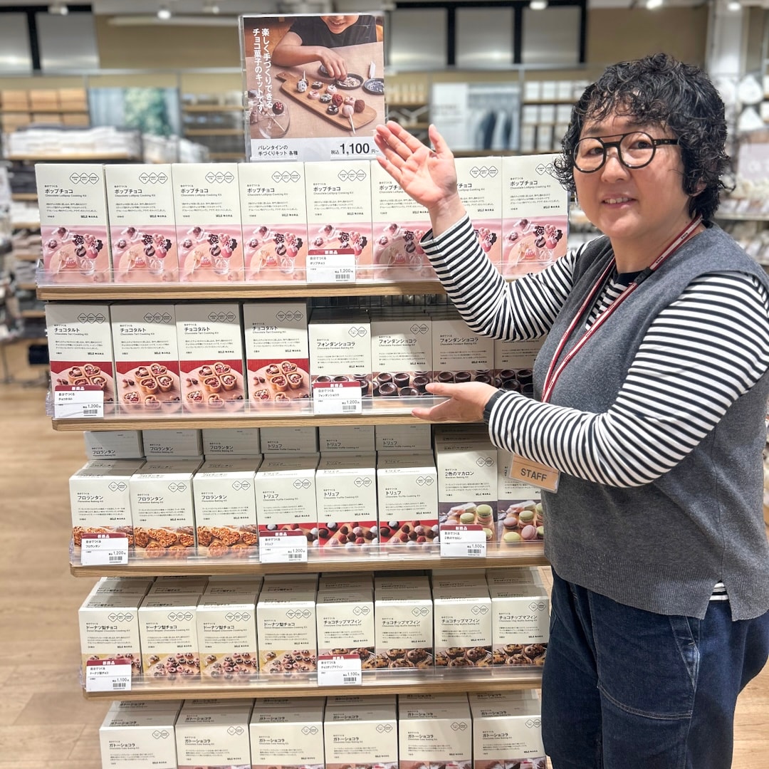 棚を指すスタッフ