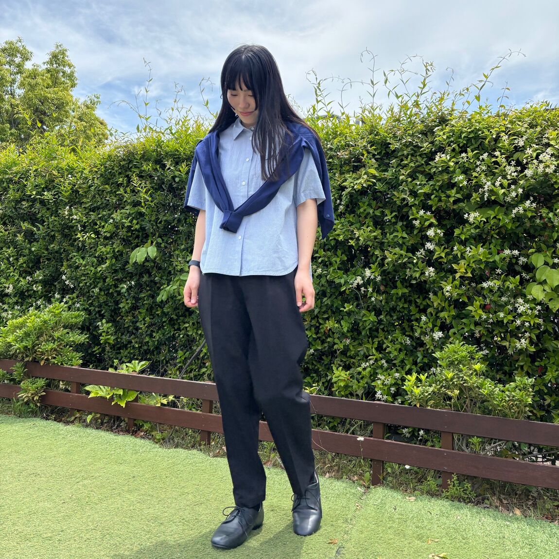 黒のテーパードパンツを着た女性