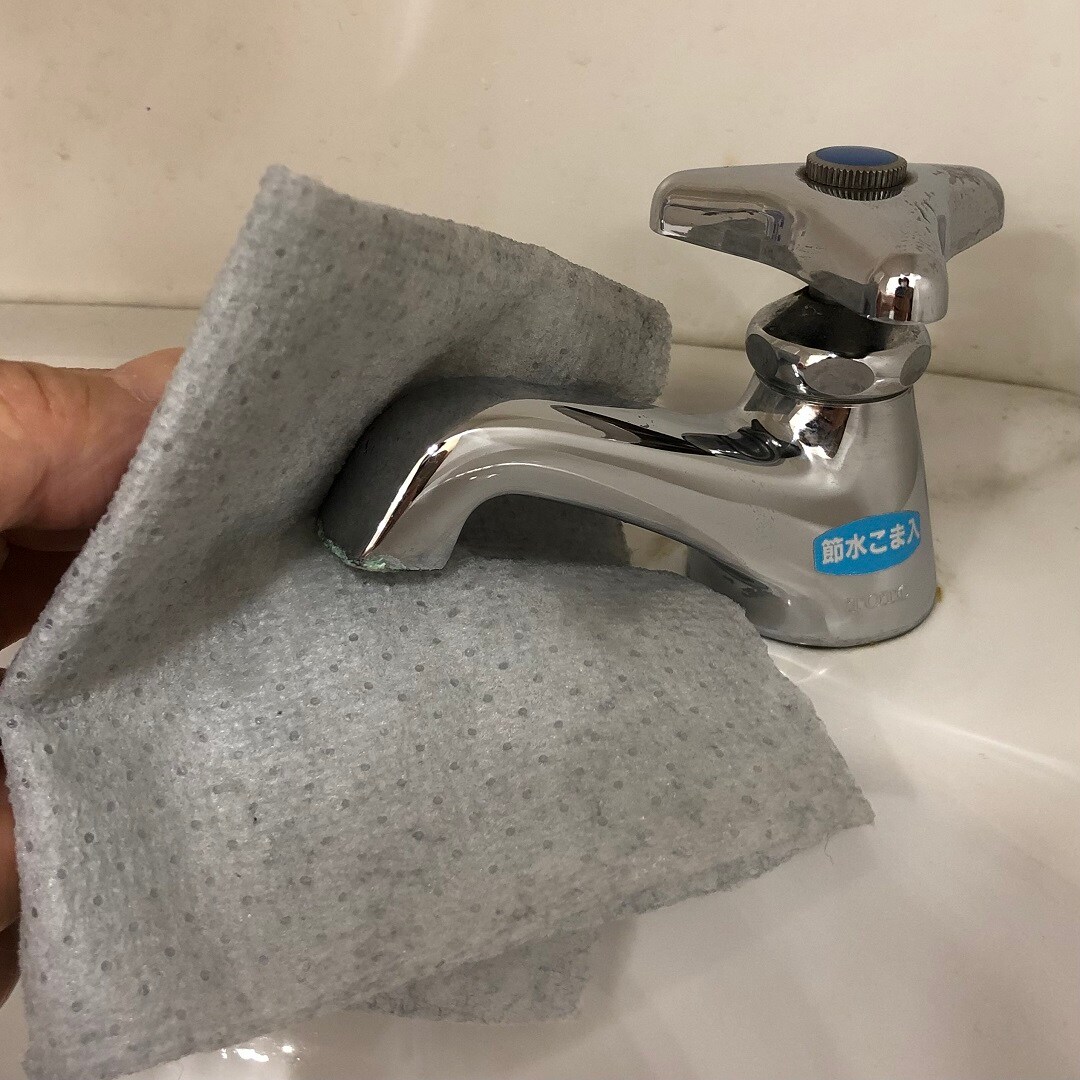 水回りの汚れ用掃除シートで蛇口を磨いている写真