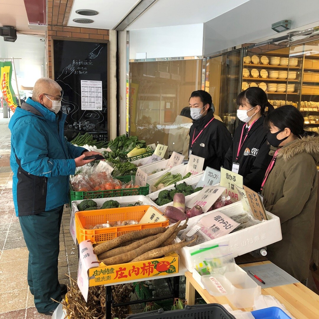 商品情報を教えてもらう高校生たち