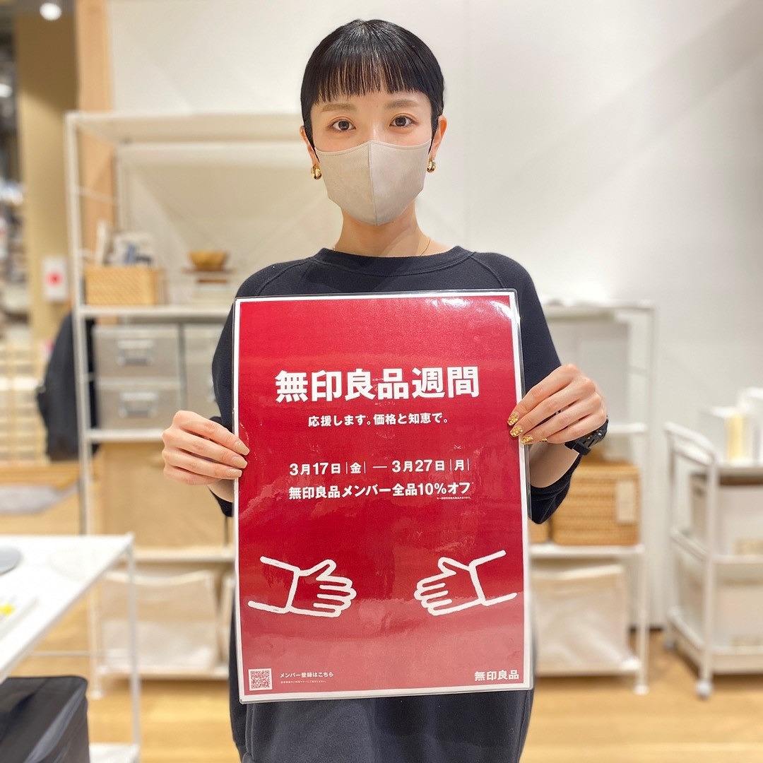 ポスターを持ったスタッフの写真