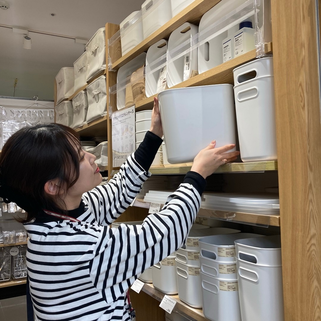 棚から商品を取るスタッフ