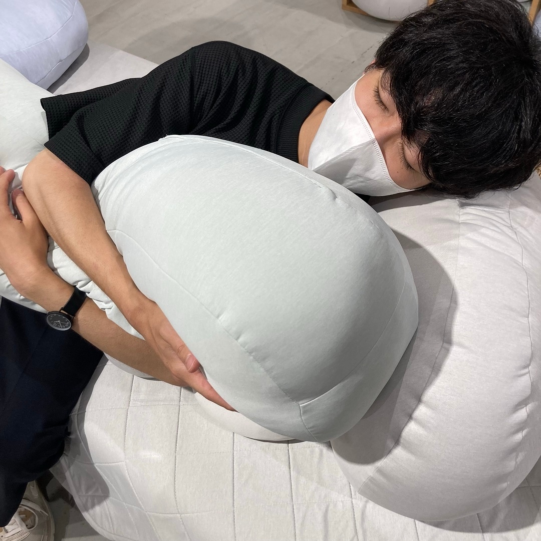 スタッフがひんやり抱き枕を抱いて寝ている写真