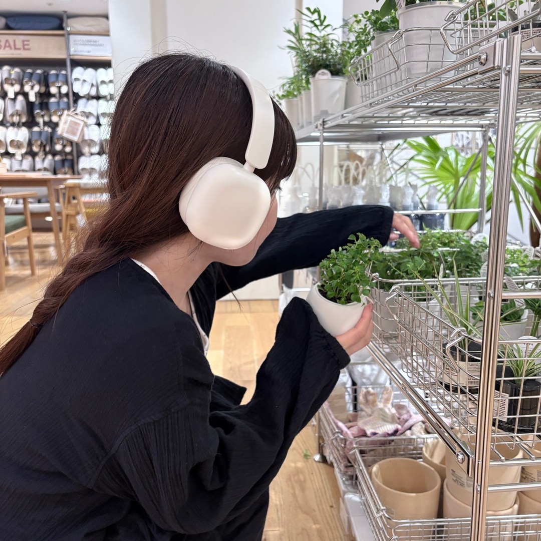 ヘッドホンを付け植物を選ぶ女性