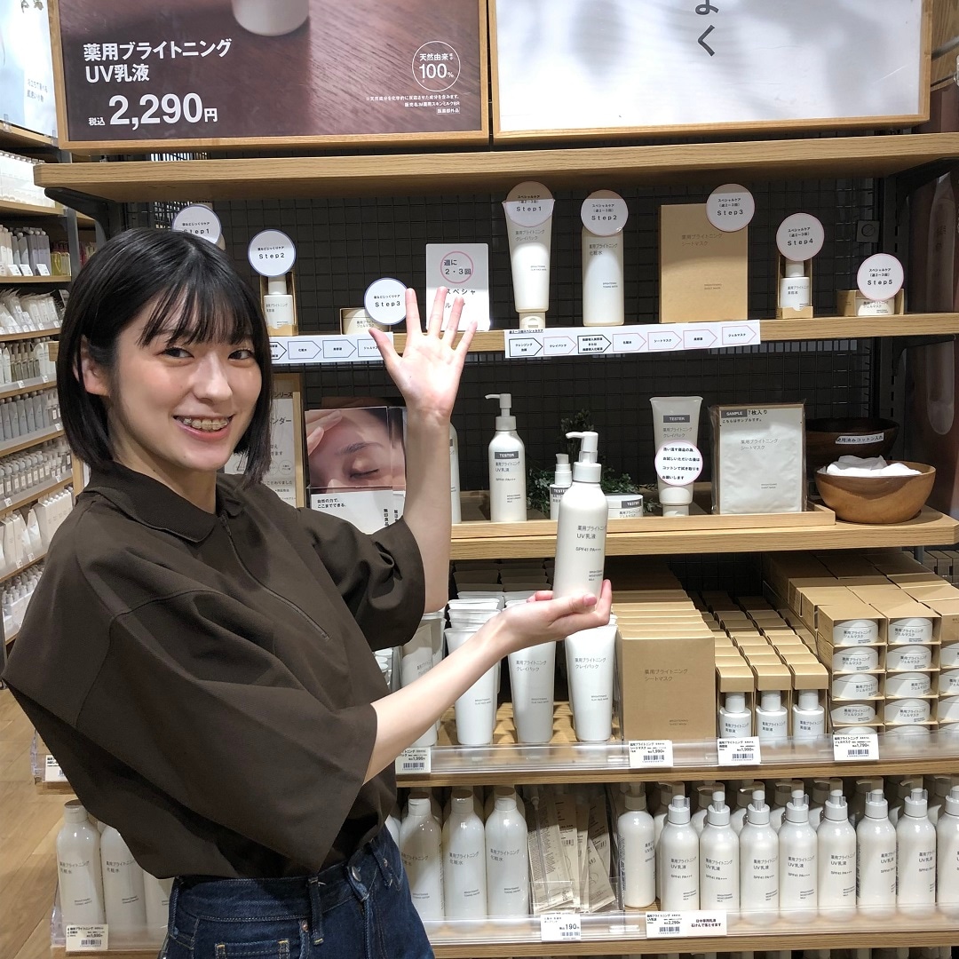薬用ブライトニング乳液と売場を紹介するスタッフ