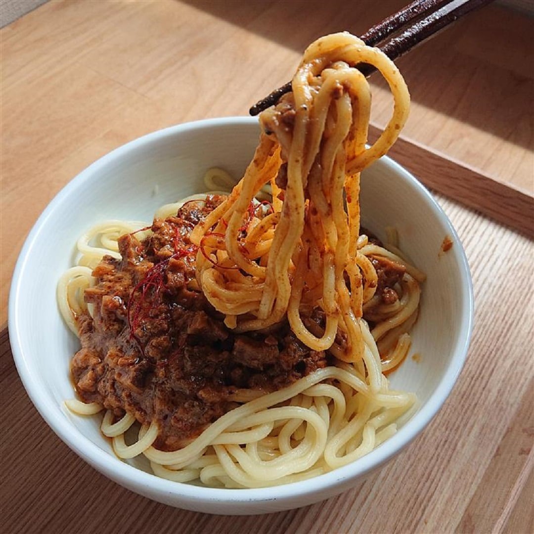 【アピタ島田】麺にかける白胡麻坦々ソース盛り付けて麺を持ち上げた画像