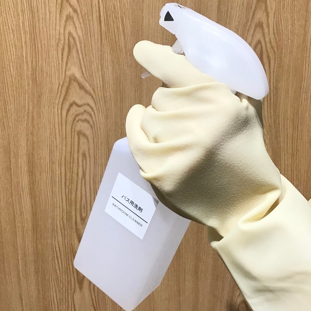 ゴム手袋をしてスプレーボトルを持つ