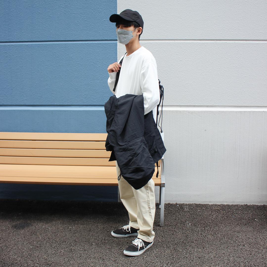 コートを手にかけて立っている写真です