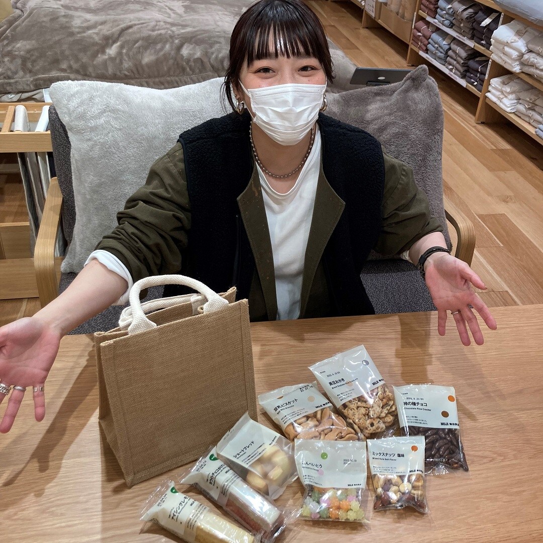 お菓子を前に微笑む女性の写真