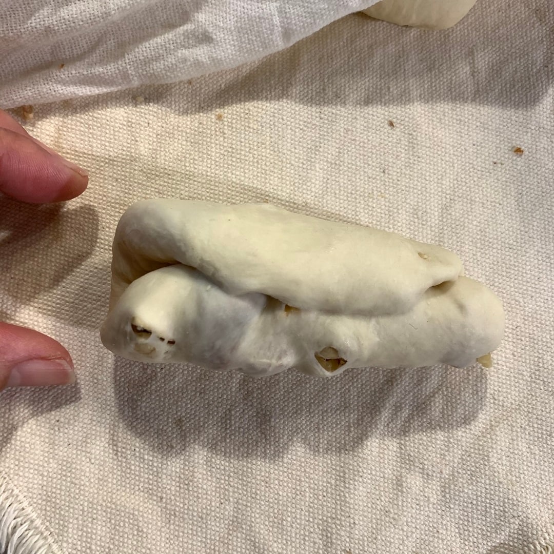平たく広げ、ロール状に丸め、片端を手で押さえ、もう片端を細く伸ばします。