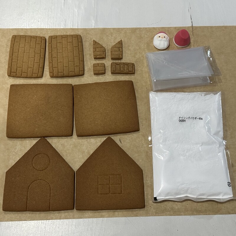 ヘクセンハウス開封画像　かべ・やね・えんとつのクッキー合わせて10枚、アイシングのもと、絞り袋1枚、サンタクロースの頭とからだ