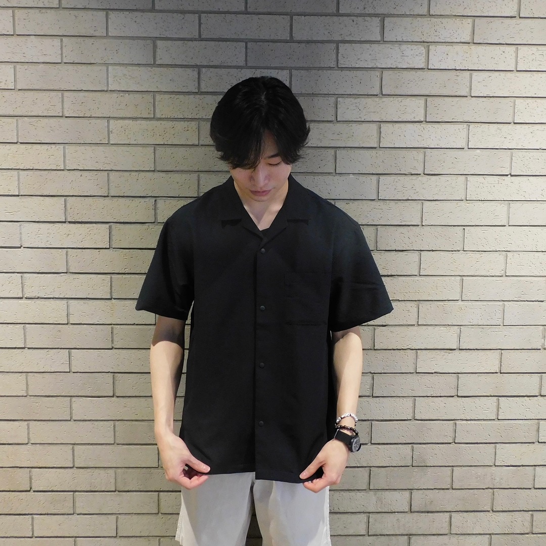 商品を着用して、シャツの裾を持っている男性　上半身