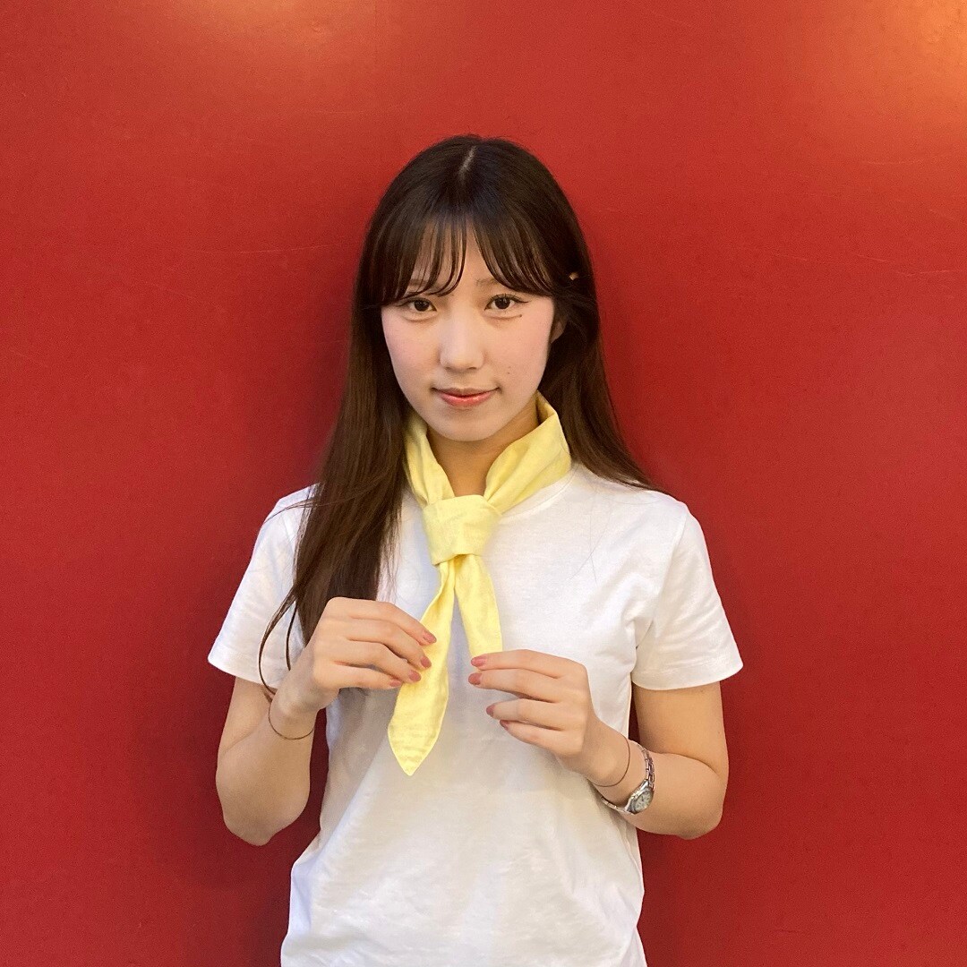 スカーフを首に巻いている女性スタッフ