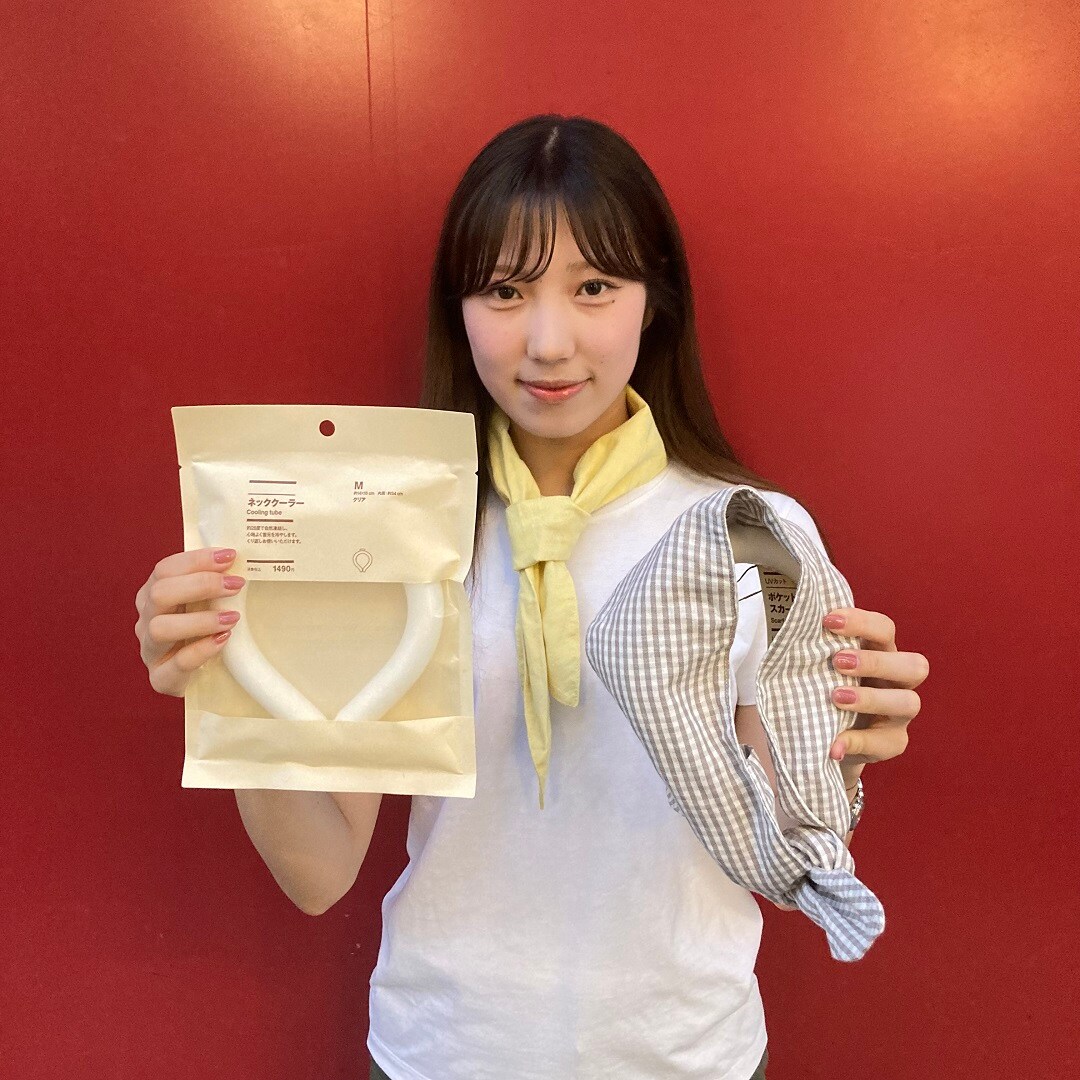 スカーフを首に巻いて、ネッククーラーを手に持っている女性スタッフ