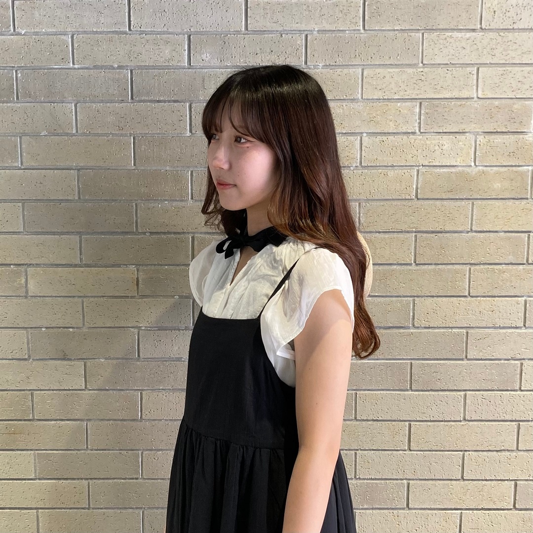 ブラウスを着た女性スタッフ 横を向いている フレンチスリーブは肩より少し下がる丈感