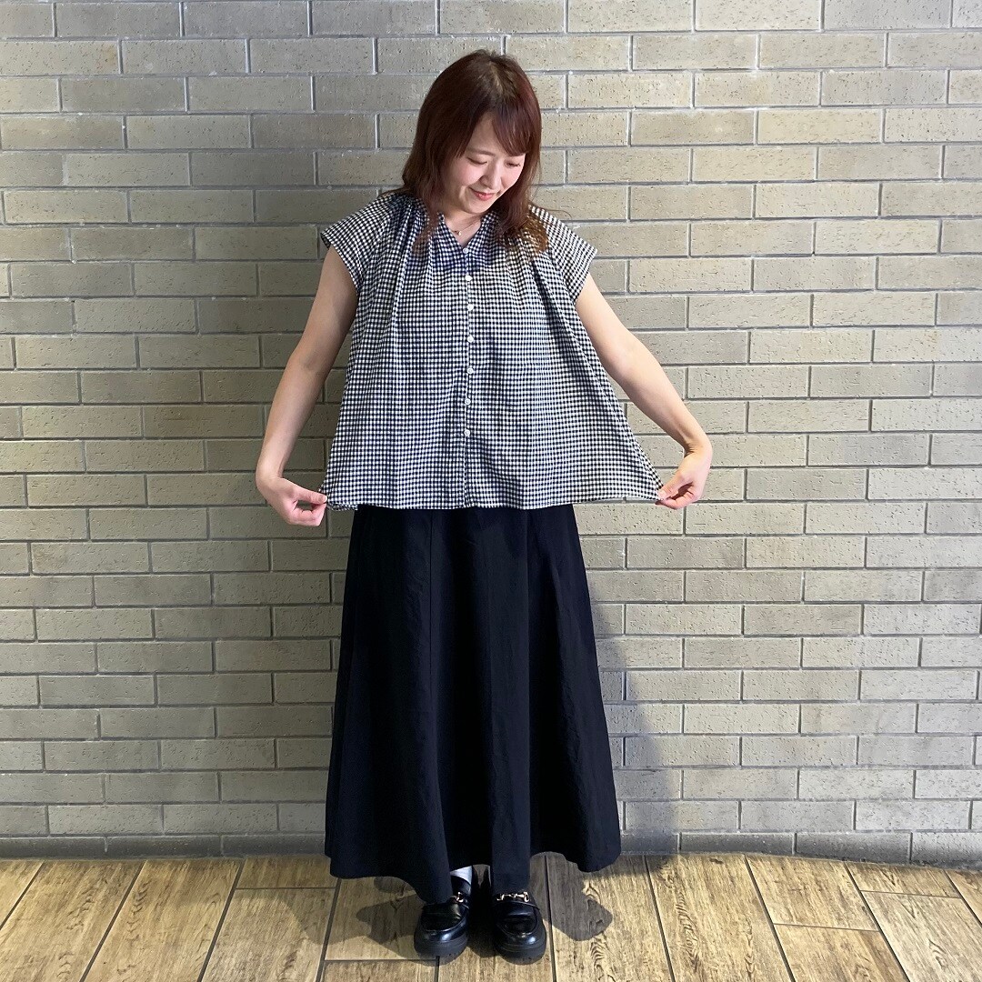 ブラウスを着た女性スタッフ 裾を広げている