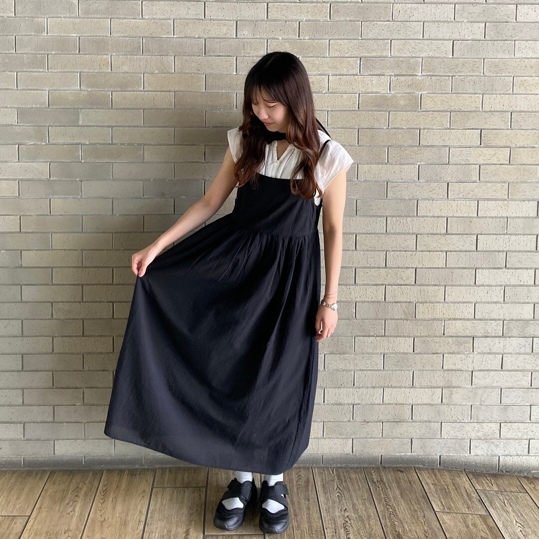 ワンピースを着ている女性スタッフ 裾を持って広げている