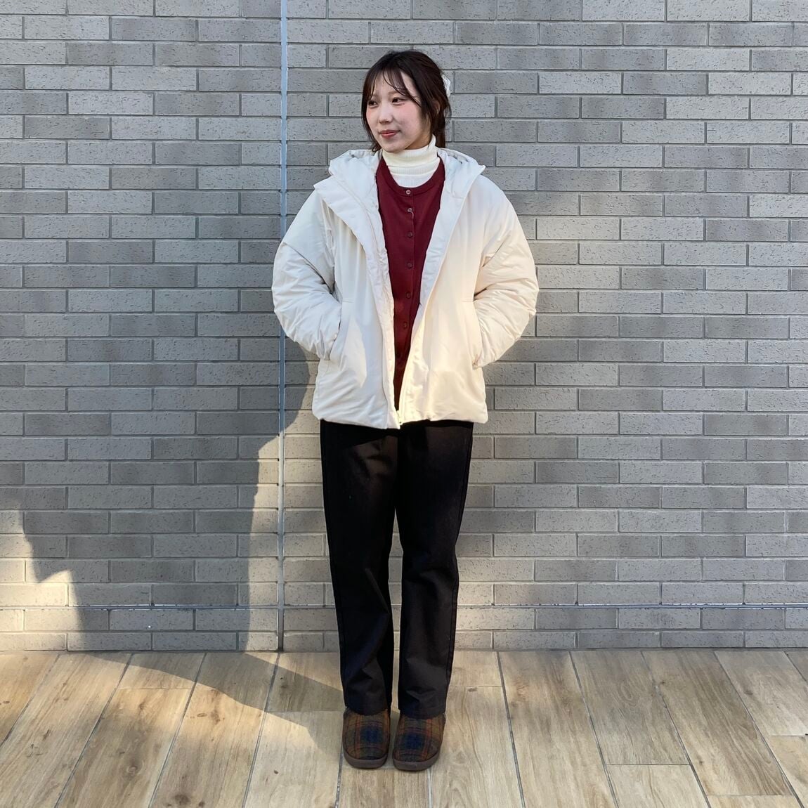 白いジャケット、赤いセーター、黒いパンツの女性