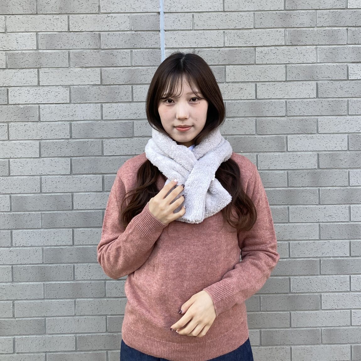ピンクのセーター、白いボアマフラーの女性上半身