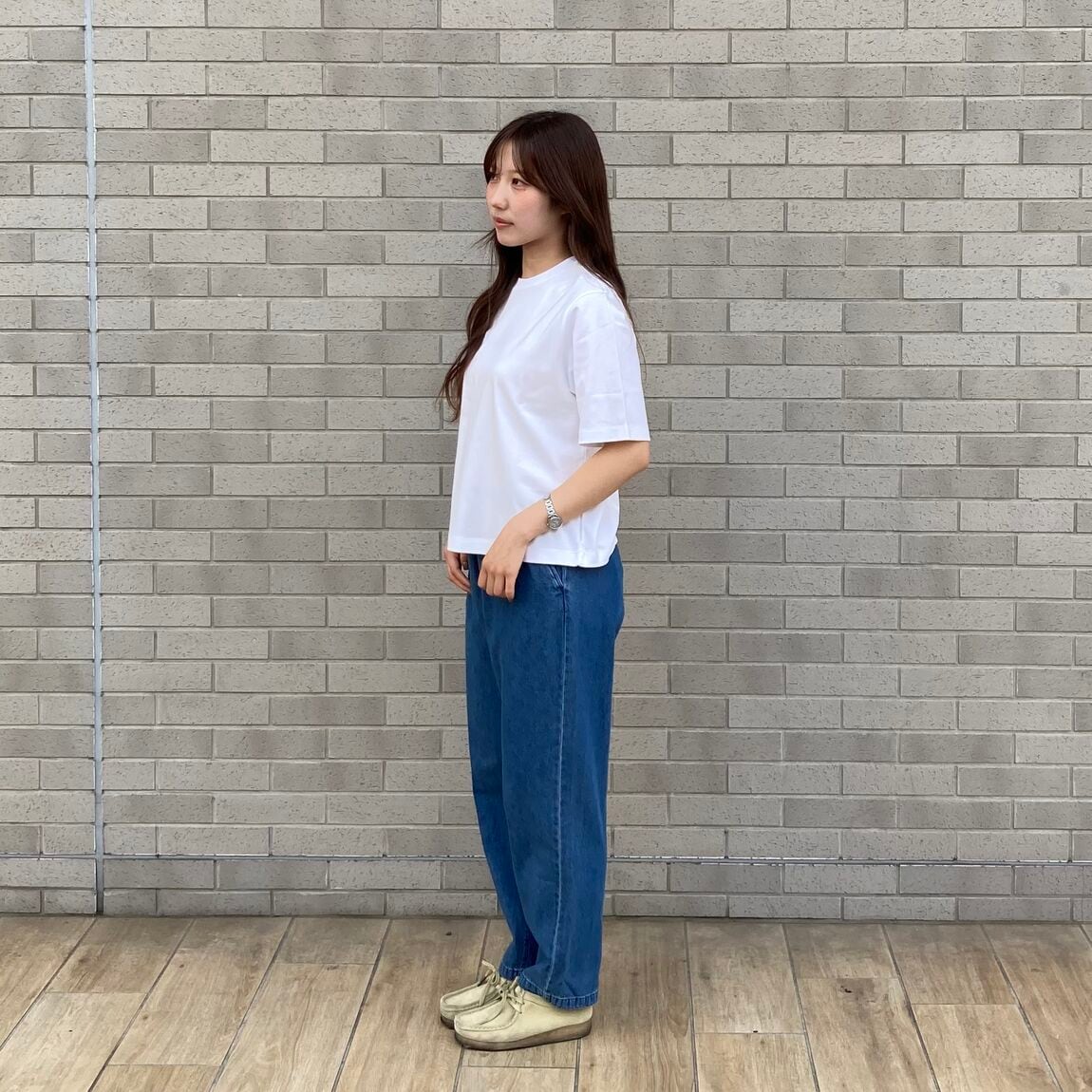 白のＴシャツとデニムを着用