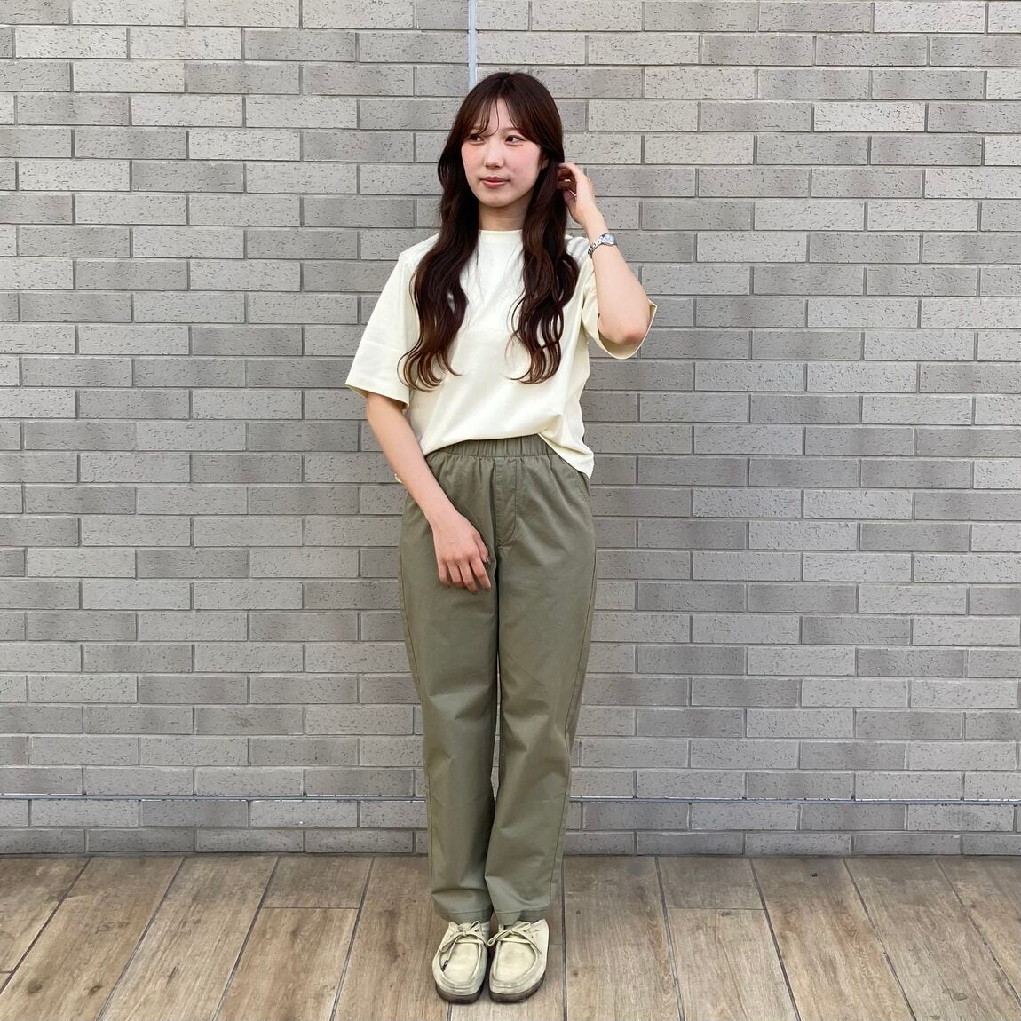 黄色のＴシャツとカーキのパンツのコーデ。Ｔシャツの裾をパンツに入れている