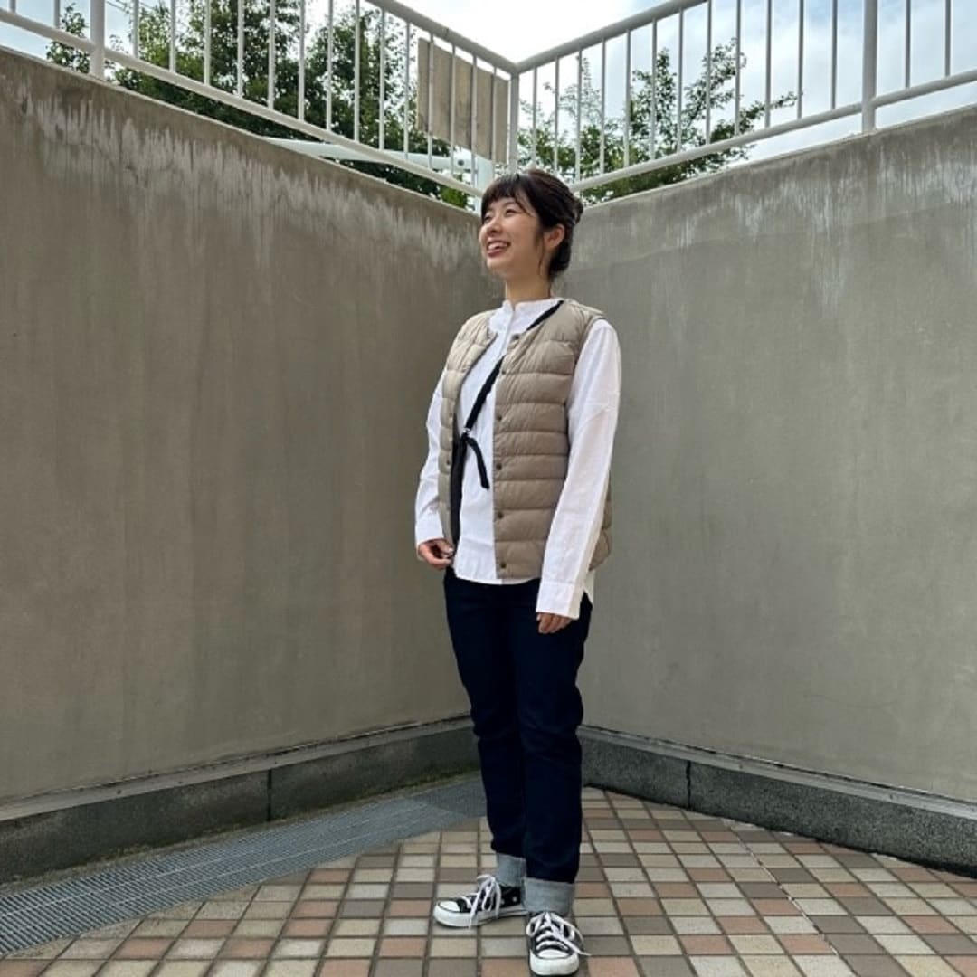 ダウンベストを着る女性スタッフ