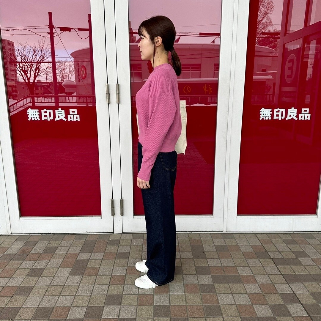 クルーネックセーターを着た女性スタッフの側面