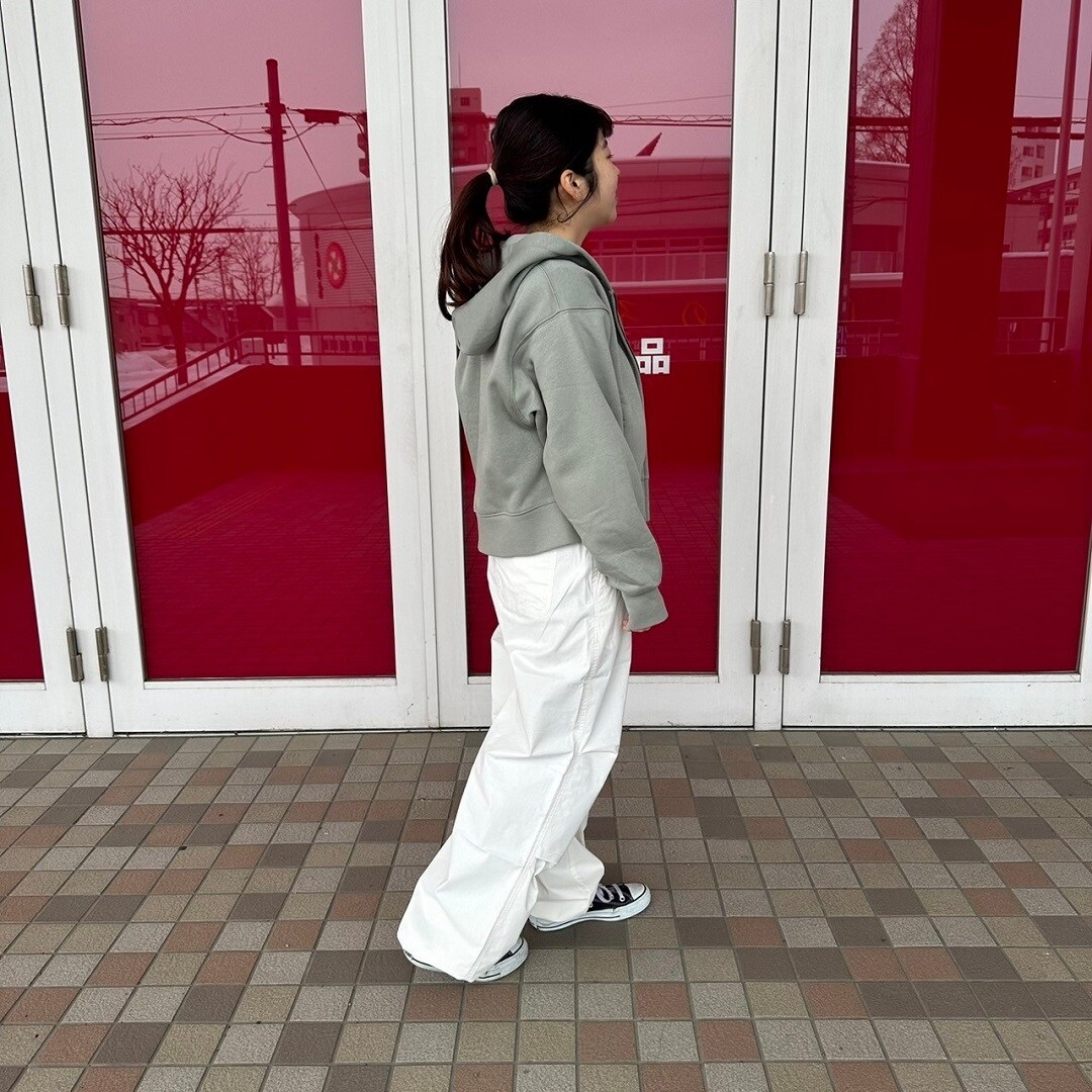 フルジップパーカーを着た女性スタッフの斜め背面