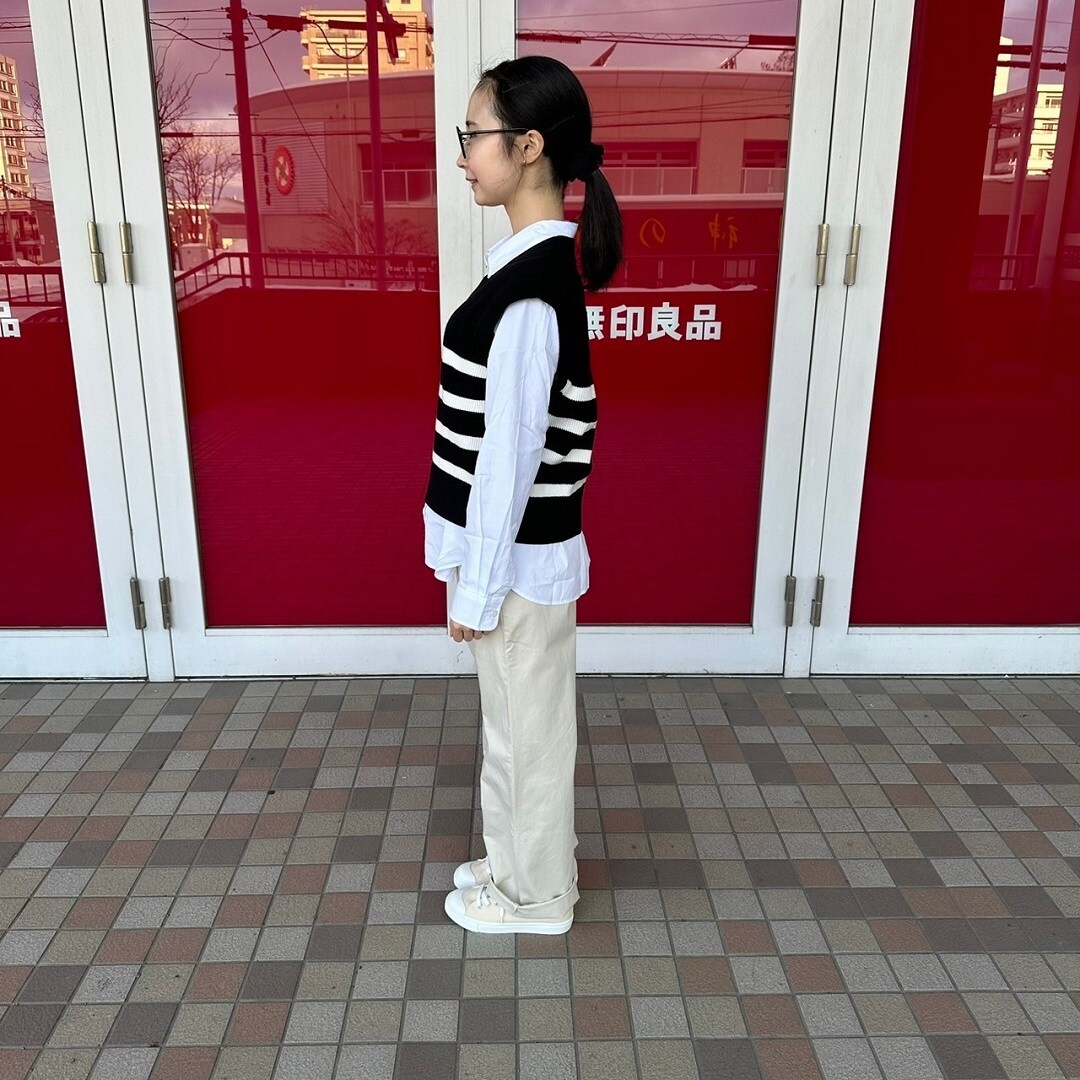 Vネックベストを着た女性スタッフの側面
