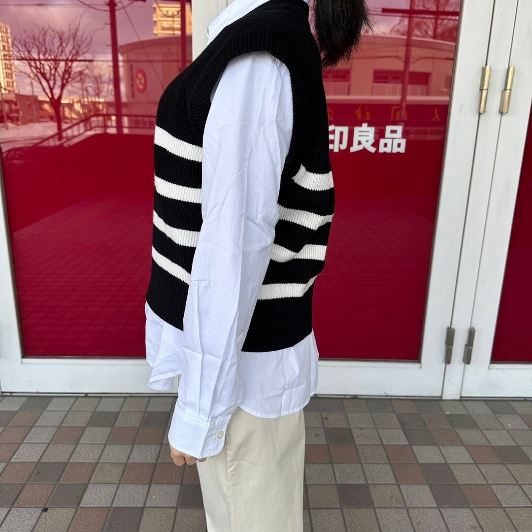 Vネックベストを着た女性スタッフのバストアップ