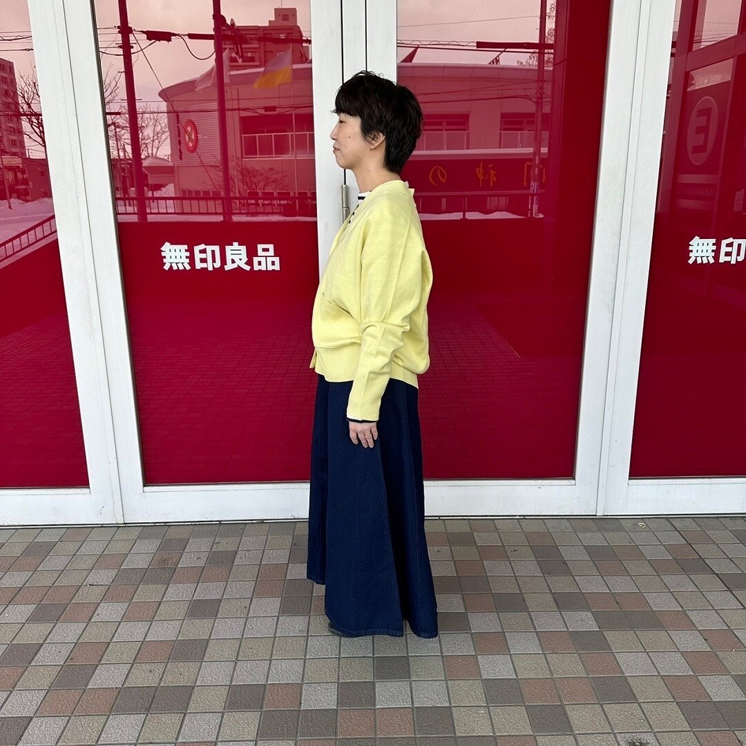 Vネックカーディガンを着た女性スタッフの側面