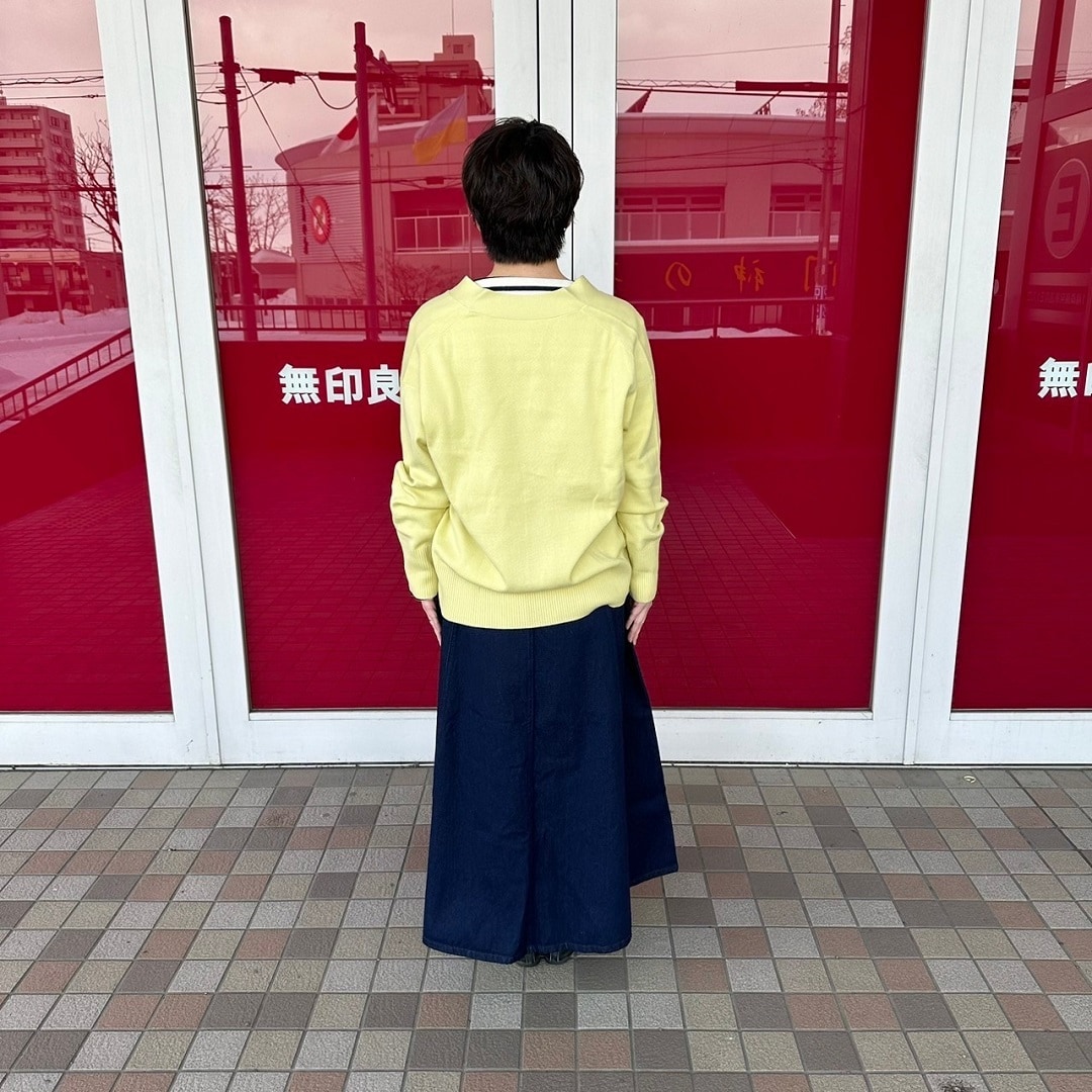 Vネックカーディガンを着た女性スタッフの背面