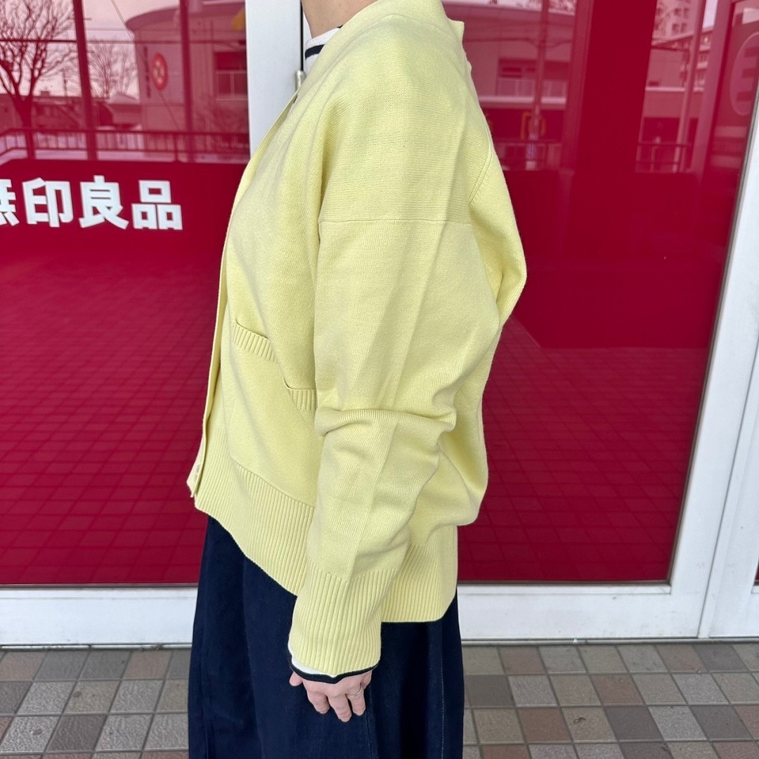 Vネックカーディガンを着た女性スタッフのバストアップ